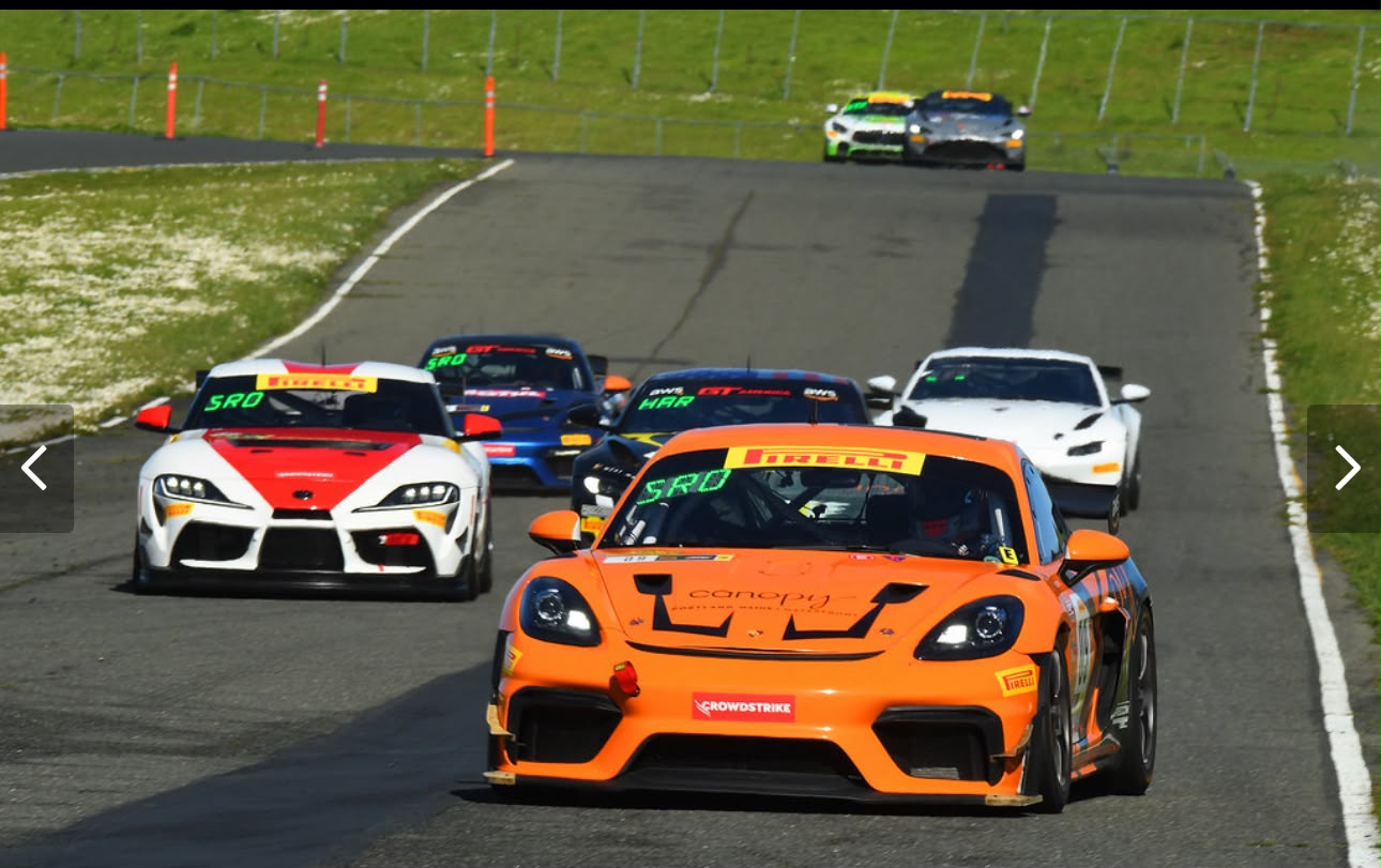Orange GT race car leading a competitive field on circuit